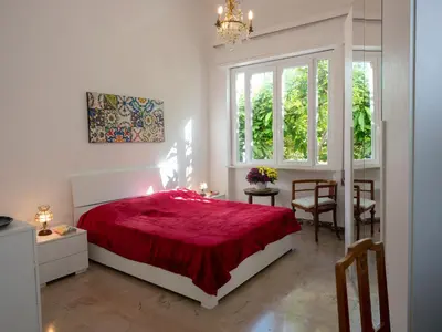 a bedroom with a red bed and a table and chairs at Villa Rosa Mondello in Mondello