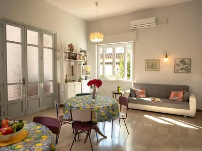 a living room with a table and a couch at Villa Rosa Mondello in Mondello