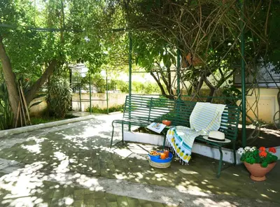 a green park bench sitting under a tree at Villa Rosa Mondello in Mondello