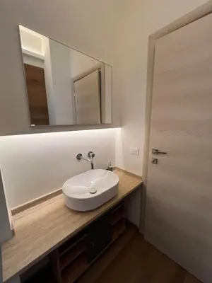 a bathroom with a white sink and a mirror at LaPignaVerde Suites in Palermo