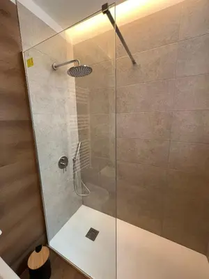 a shower with a glass door in a bathroom at LaPignaVerde Suites in Palermo