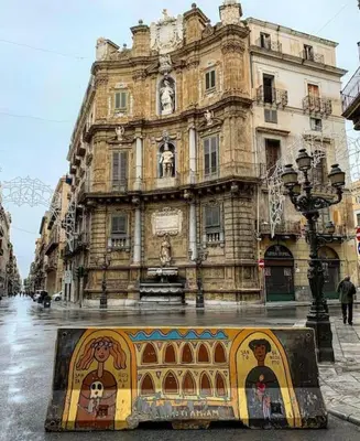 an old building with a mural in front of it at 145 Maqueda Palermo in Palermo
