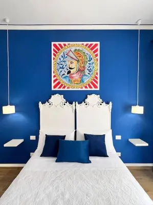 a blue bedroom with a bed with blue walls at Casa Vacanze Tirreno in Trabia