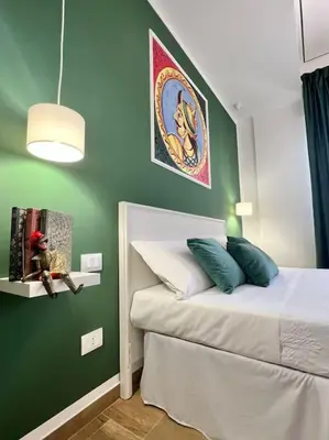 a small bedroom with a green wall with a bed at Casa Vacanze Tirreno in Trabia