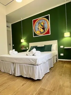 a bedroom with a large bed with green walls at Casa Vacanze Tirreno in Trabia