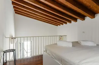 a bedroom with a white bed and wooden ceilings at GuestHost - Vucciria & La Cala Lovely Apartment with Terrace in Palermo