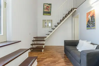 a living room with a couch and stairs at GuestHost - Vucciria & La Cala Lovely Apartment with Terrace in Palermo
