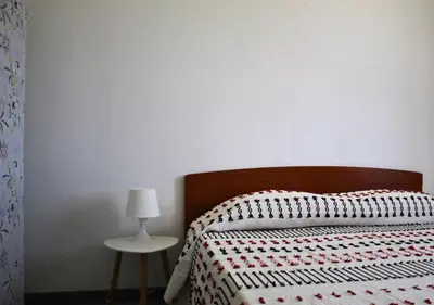 a bedroom with a bed and a table with a lamp at Villa Giorgia in Alcamo