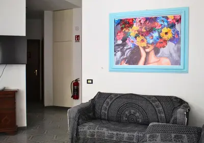 a couch in a living room with a painting on the wall at Villa Giorgia in Alcamo