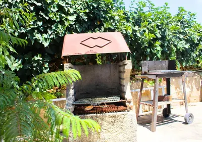a barbecue grill with a table in a garden at Villa Giorgia in Alcamo