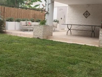a patio with a bench and a table in a yard at Villa Regina ai Faraglioni di Scopello in Scopello
