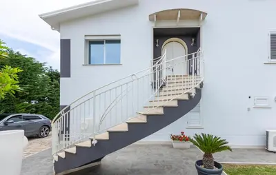 a white house with stairs on the side of it at Cozy Home In Partinico in Partinico