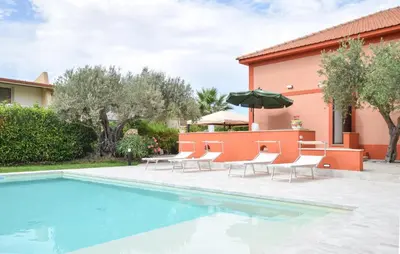 a pool with chairs and a table with an umbrella at Amazing Home In Castellammare Del Golf in Castellammare del Golfo