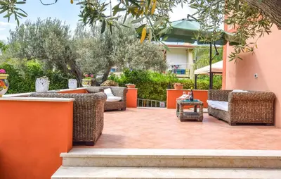 a patio with wicker chairs and a table at Amazing Home In Castellammare Del Golf in Castellammare del Golfo