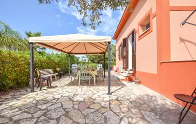 a patio with an umbrella and a table and chairs at Amazing Home In Castellammare Del Golf in Castellammare del Golfo