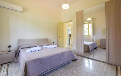 a bedroom with a bed and a mirror at Amazing Home In Castellammare Del Golf in Castellammare del Golfo