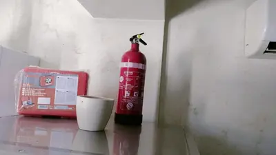 a red bottle sitting on a table next to a cup at Casa Stella in Palermo