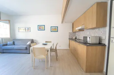 a kitchen and living room with a table and a couch at Central Station Apartment 24 in Palermo