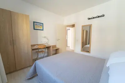 a white bedroom with a bed and a desk at Central Station Apartment 24 in Palermo
