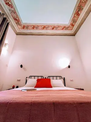 a bedroom with a bed with a ceiling at Donna Oliva Guest House in Palermo