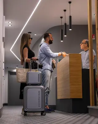a group of people standing in an office with luggage at La Dimora dei Paladini in Bagheria
