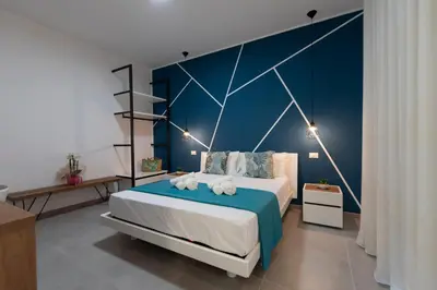 a bedroom with a large bed with a blue wall at Bed and Breakfast Da Francesca in Castelluzzo