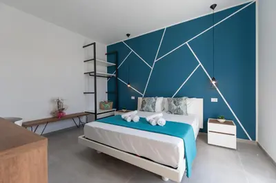 a bedroom with a large bed with a blue wall at Bed and Breakfast Da Francesca in Castelluzzo
