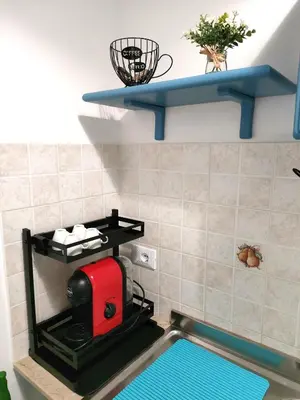a kitchen with a red espresso machine on a shelf at Casa Magarìa in Palermo