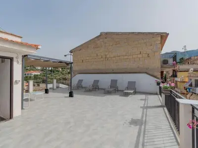 a patio with chairs and a brick wall at Casa Vacanze Ginevra in Mandra Capreria