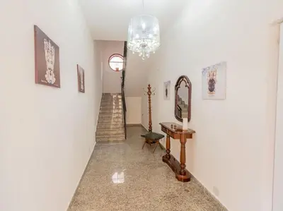 a hallway with a chandelier and a stairway at Casa Vacanze Ginevra in Mandra Capreria