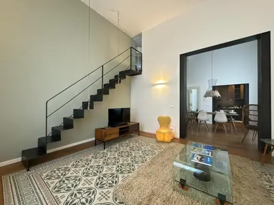 a living room with a staircase and a table at Laura's Apartment in Palermo