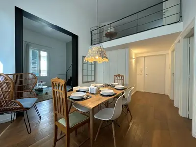a dining room with a wooden table and chairs at Laura's Apartment in Palermo