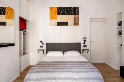a bedroom with a bed in a white room at Azizò, la Gialla in Palermo