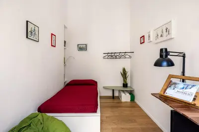 a room with a red bed and a table at Azizò, la Gialla in Palermo