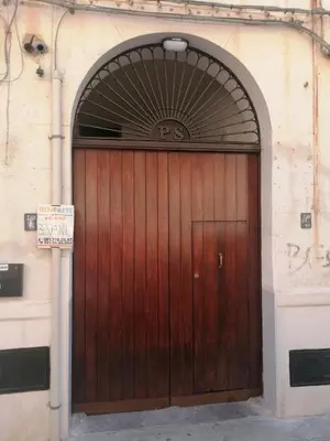 a brown wooden door with an arch above it at Azizò, la Gialla in Palermo