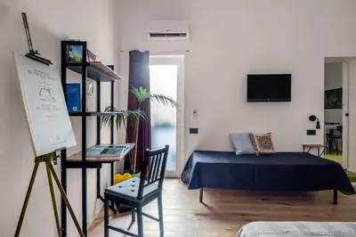 a bedroom with a bed and a chair in a room at Azizò, la Verde in Palermo