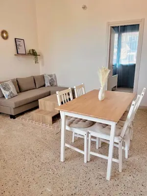 a wooden table and chairs in a living room at Sicily Apartment 4 - BLUE WAVES in Campofelice di Roccella