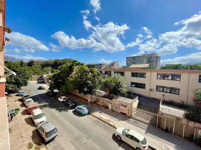 a city street with cars parked in a parking lot at Appartamento vicino il centro in Palermo