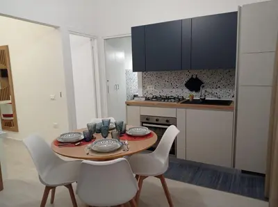 a kitchen with a table and chairs and a kitchen with a stove at Casa Grazia in Partinico