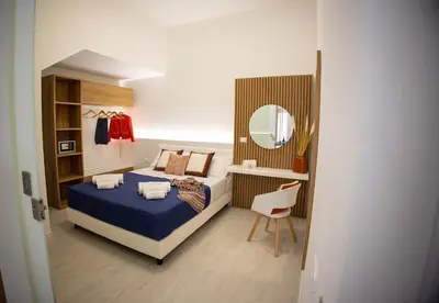 a bedroom with a bed and a mirror and a chair at Casa Grazia in Partinico