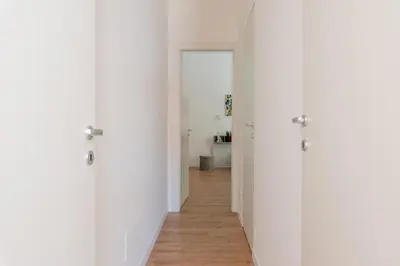 an empty hallway with white walls and wooden floors at Casetta al Molo di Mondello by Wonderful Italy in Palermo