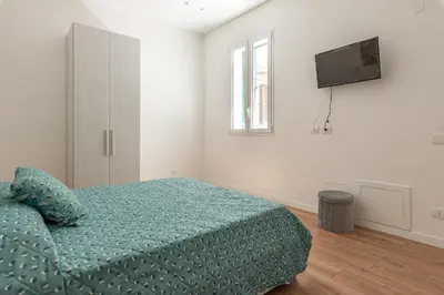 a bedroom with a bed and a flat screen tv at Casetta al Molo di Mondello by Wonderful Italy in Palermo