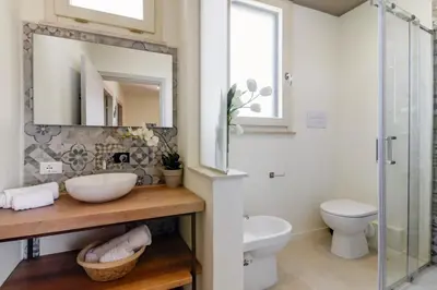 a bathroom with a sink and a toilet and a mirror at GuestHost - Palermo's Rooftop - Apt with Panoramic Terrace in Palermo