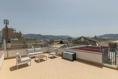 a balcony with chairs and a television on a roof at GuestHost - Palermo's Rooftop - Apt with Panoramic Terrace in Palermo