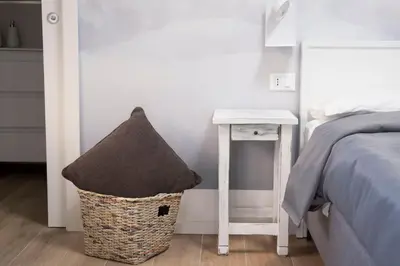 a bedroom with a bed and a stool next to a table at Villa due Scale in Palermo