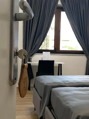 a hotel room with two beds and a window at Villa due Scale in Palermo
