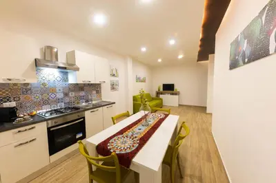 a kitchen with a table and chairs in a room at I RE di SICILIA 2 in Palermo