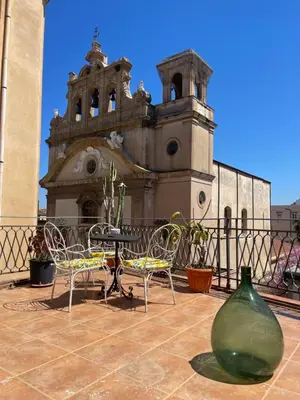 a building with chairs and a table and a vase at Le Terrazze Élite Apartment in Palermo