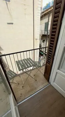 a balcony with a chair sitting on a porch at caZA' Capo 40MQ nel centro di Palermo in Palermo