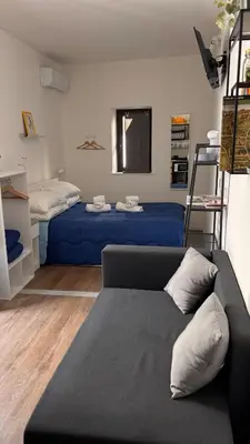 a living room with a couch and a bed at caZA' Capo 40MQ nel centro di Palermo in Palermo
